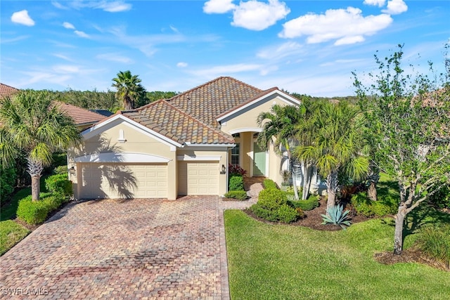 view of front of property featuring driveway, stucco siding, a front lawn, a tiled roof, and a garage