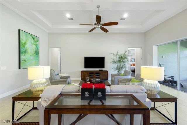 living room with ceiling fan, light hardwood / wood-style floors, and a tray ceiling