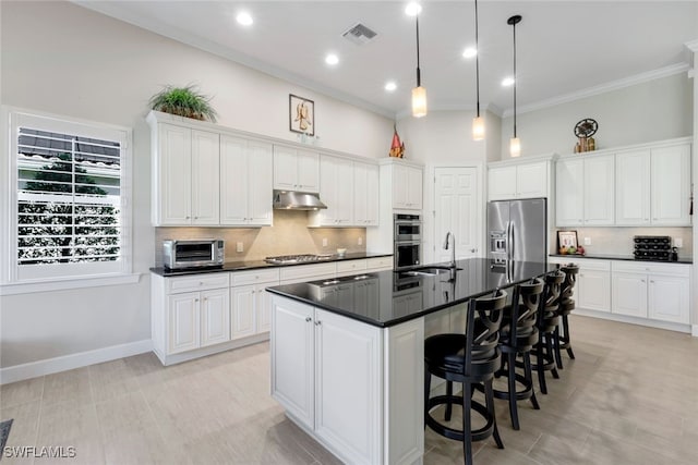 kitchen featuring appliances with stainless steel finishes, dark countertops, under cabinet range hood, a toaster, and visible vents