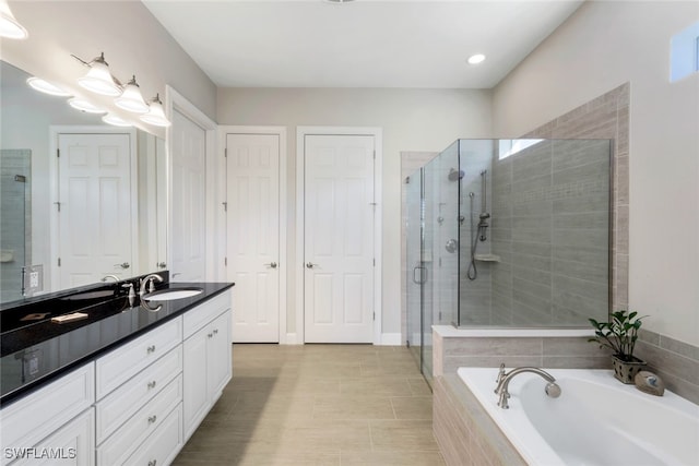full bathroom featuring vanity, a garden tub, and a shower stall