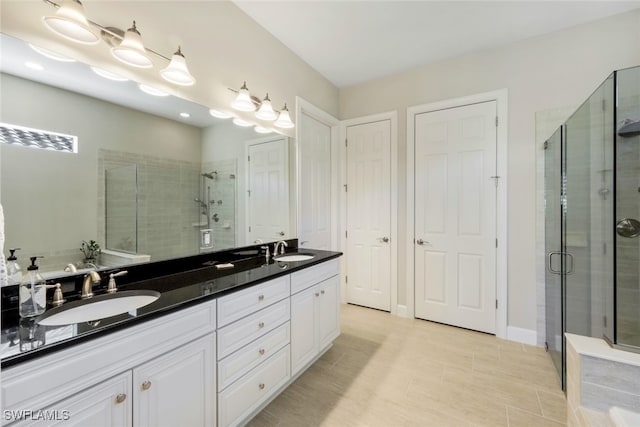 full bathroom featuring double vanity, a sink, and a stall shower