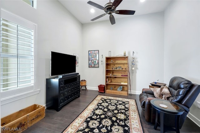 living area with lofted ceiling, ceiling fan, and dark hardwood / wood-style floors