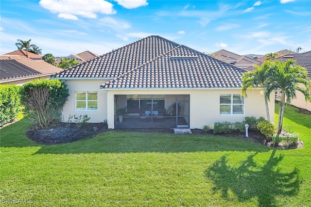 rear view of house featuring a lawn, a tile roof, and stucco siding
