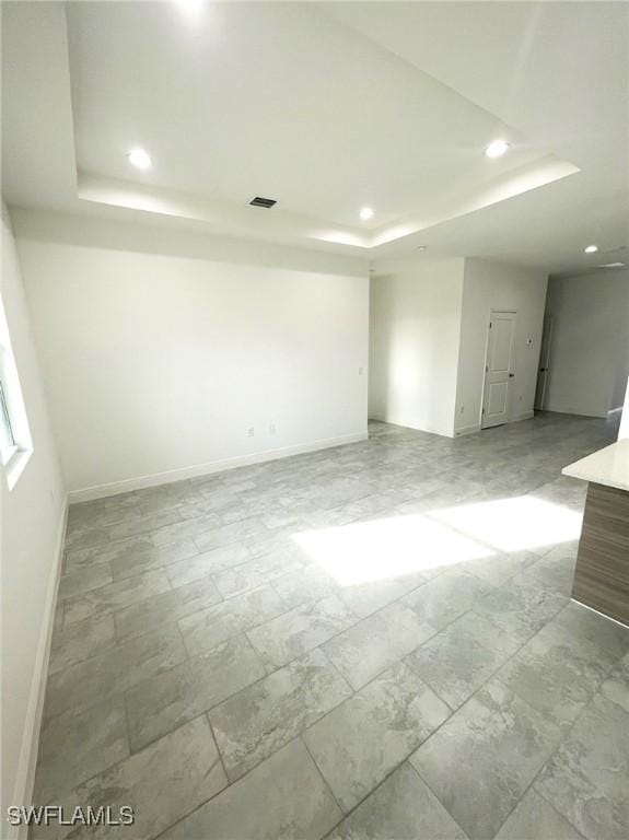 unfurnished room featuring a raised ceiling