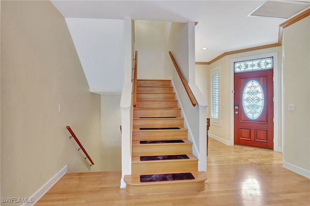 entrance foyer featuring crown molding and light wood-type flooring