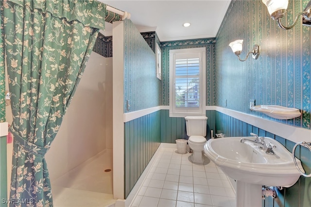 bathroom featuring tile patterned floors, toilet, ornamental molding, and a shower