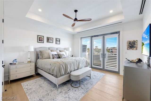 bedroom featuring access to outside, a raised ceiling, and ceiling fan