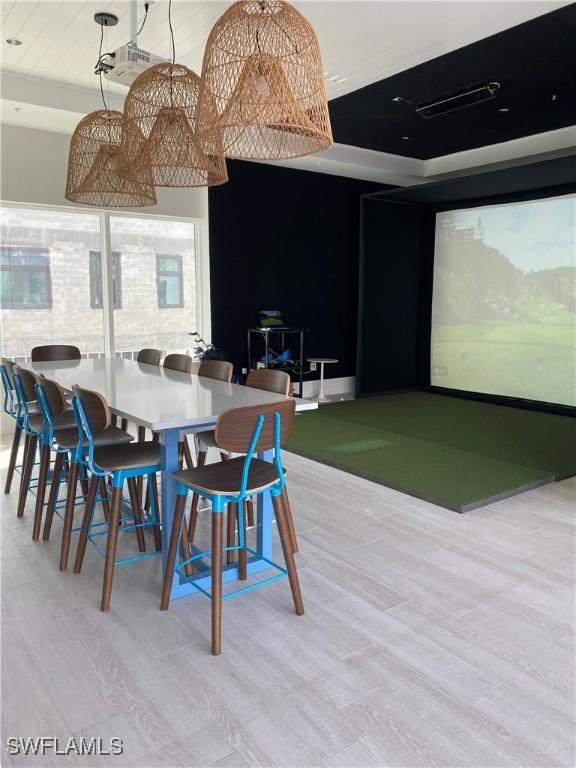 dining area with light hardwood / wood-style flooring and golf simulator