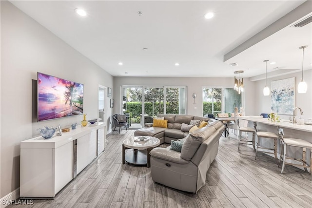 living room featuring sink and light hardwood / wood-style flooring