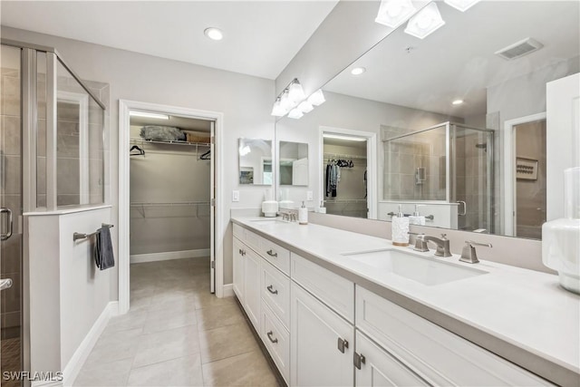 bathroom with tile patterned floors, vanity, and walk in shower