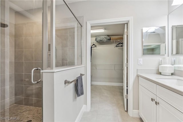 bathroom with tile patterned flooring, vanity, and a shower with shower door