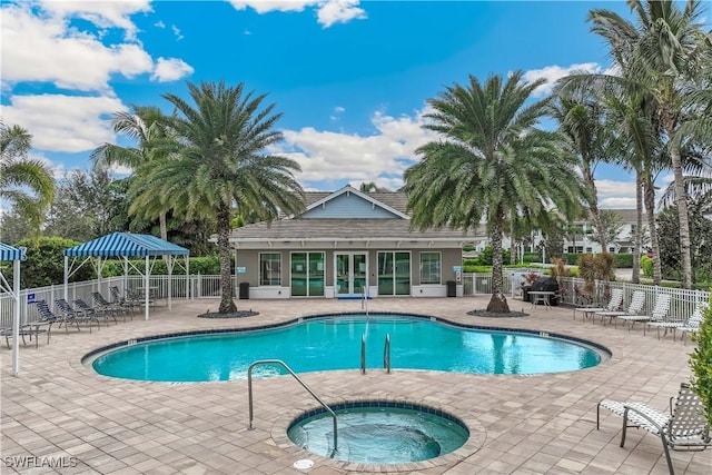 view of swimming pool with a patio area and a hot tub