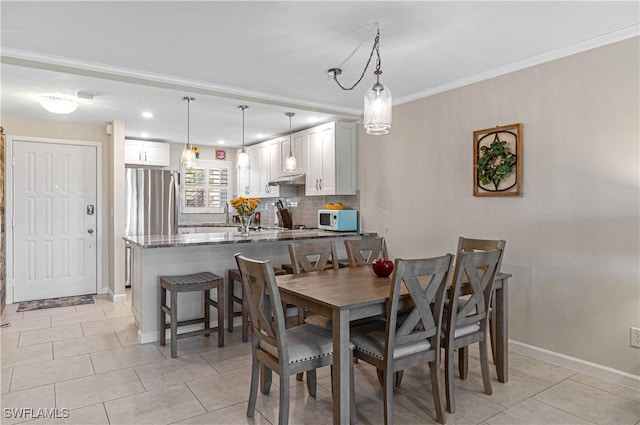 dining room with crown molding and light tile patterned floors