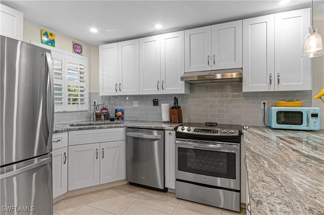 kitchen with white cabinetry, sink, stainless steel appliances, light stone counters, and light tile patterned floors