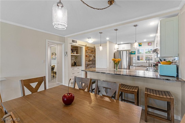 dining space featuring ornamental molding and sink