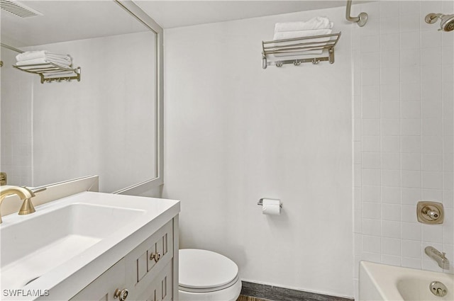 full bathroom with hardwood / wood-style floors, vanity, toilet, and tiled shower / bath