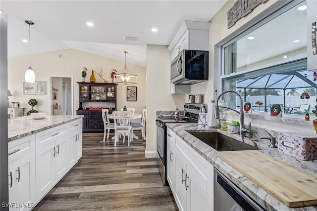 kitchen with lofted ceiling, white cabinetry, sink, and appliances with stainless steel finishes