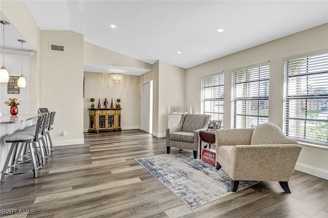 living room with dark hardwood / wood-style flooring, an inviting chandelier, and lofted ceiling