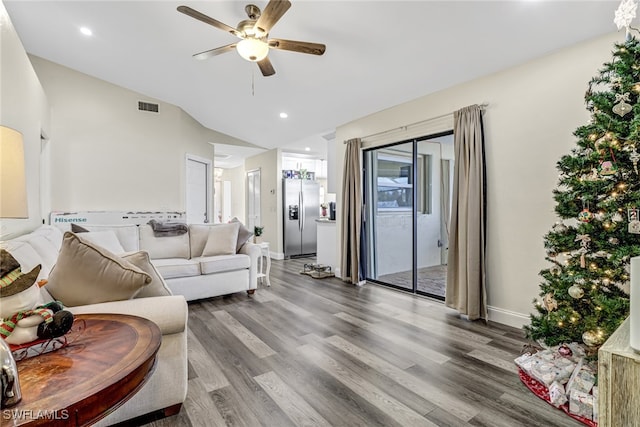 living room with hardwood / wood-style flooring, vaulted ceiling, and ceiling fan