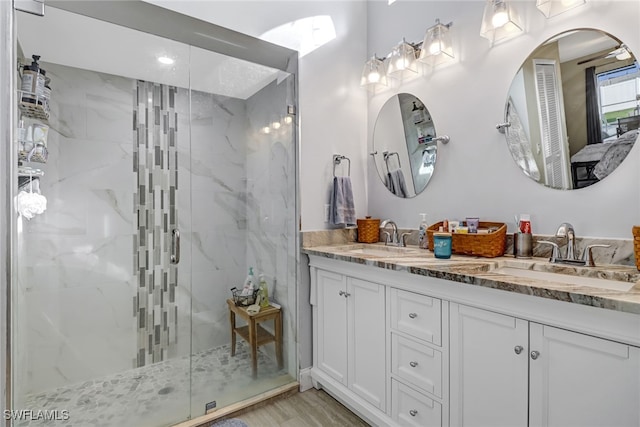 bathroom featuring wood-type flooring, vanity, and walk in shower