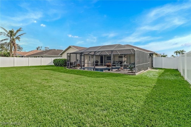 back of property with a yard, a patio area, and a lanai