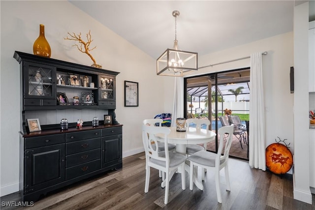 dining room with lofted ceiling, an inviting chandelier, and dark wood-type flooring