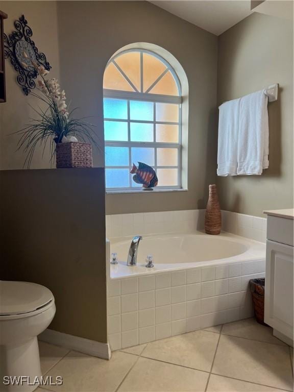 bathroom with tiled bath, tile patterned flooring, vanity, and toilet