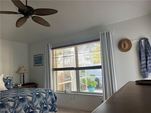 carpeted bedroom with ceiling fan and multiple windows