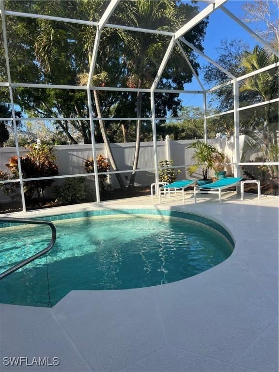 view of swimming pool featuring a patio and a lanai