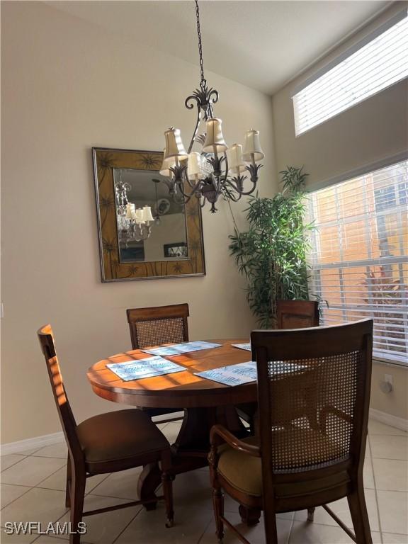 tiled dining space featuring a chandelier