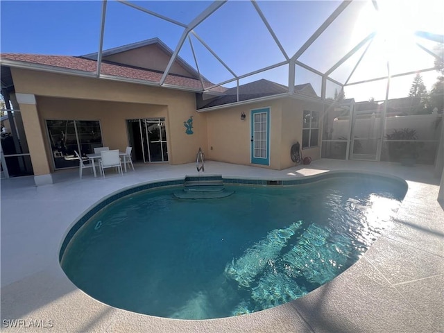 view of swimming pool with a patio and a lanai