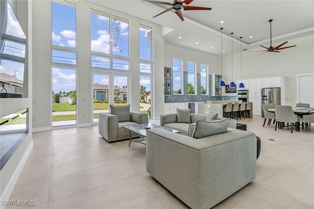 living room featuring plenty of natural light, a high ceiling, and a ceiling fan