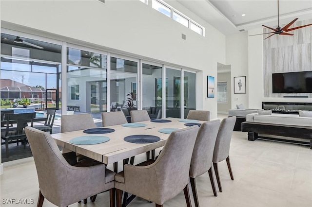 dining space with ceiling fan, a high ceiling, and visible vents