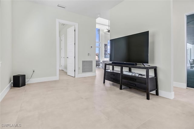 living room featuring baseboards, visible vents, and a ceiling fan