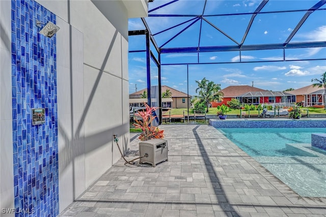 view of swimming pool featuring a patio, a lanai, and a residential view