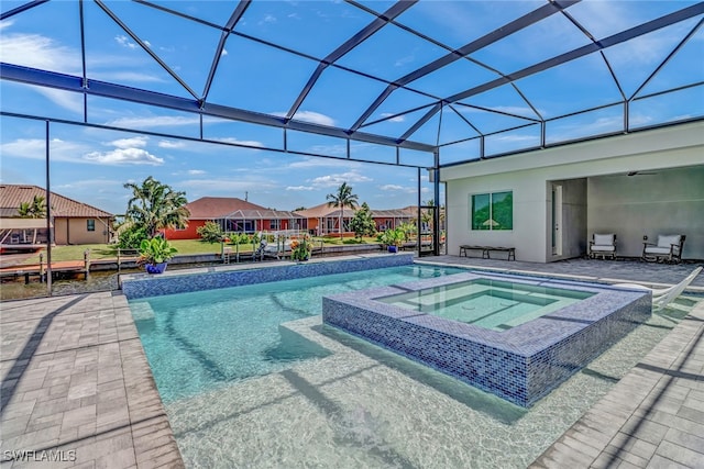 view of pool featuring glass enclosure, a pool with connected hot tub, a patio area, and a residential view