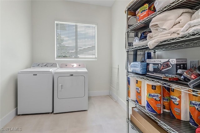 washroom with laundry area, baseboards, and washing machine and clothes dryer