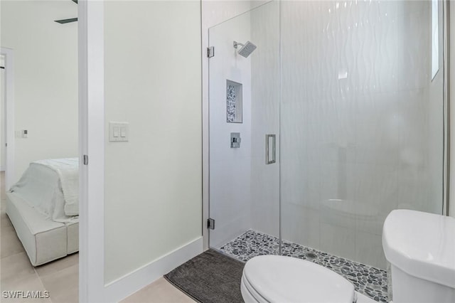 full bath with baseboards, a shower stall, toilet, and tile patterned floors