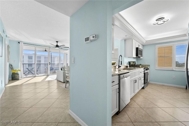 kitchen with white cabinets, appliances with stainless steel finishes, light tile patterned flooring, and sink