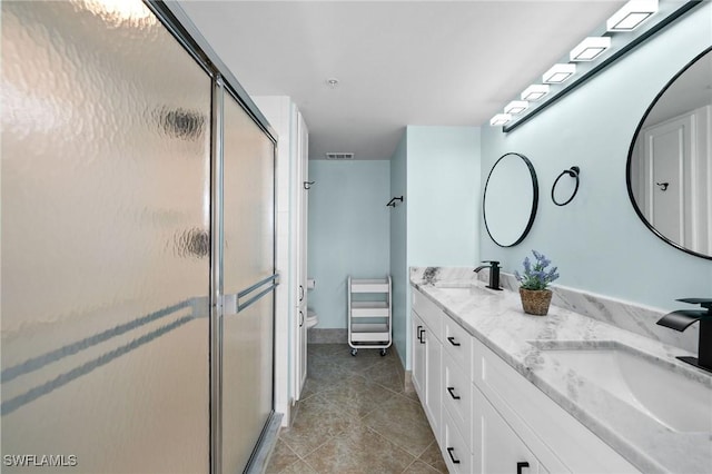 bathroom with tile patterned flooring, vanity, and walk in shower