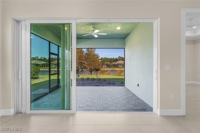 doorway with ceiling fan and light tile patterned flooring