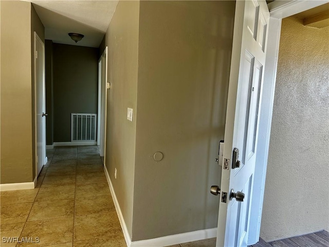 hallway with tile patterned floors