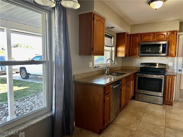 kitchen with appliances with stainless steel finishes, sink, and light tile patterned floors