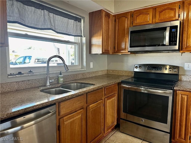 kitchen featuring stainless steel appliances, sink, and light tile patterned floors