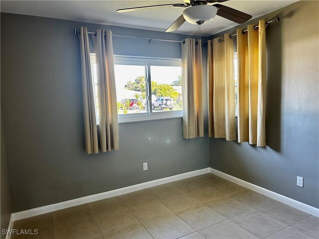 tiled spare room featuring ceiling fan