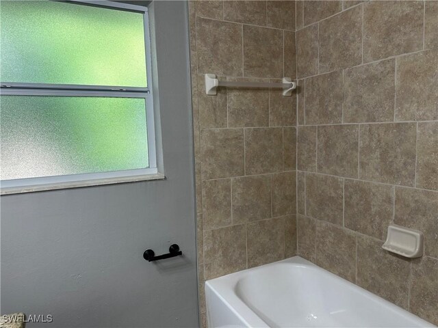 bathroom featuring tiled shower / bath and a healthy amount of sunlight