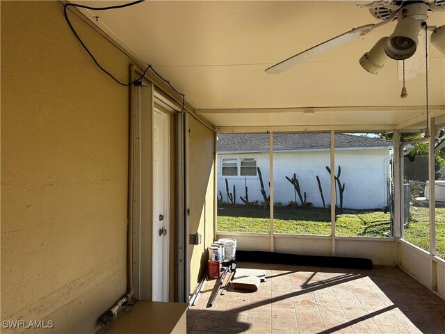 unfurnished sunroom featuring ceiling fan