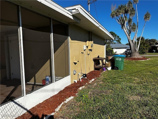 view of home's exterior featuring a yard and a sunroom