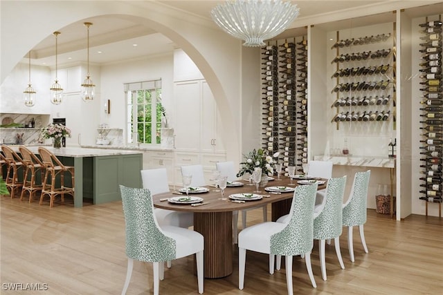 dining room with light hardwood / wood-style floors, crown molding, and an inviting chandelier