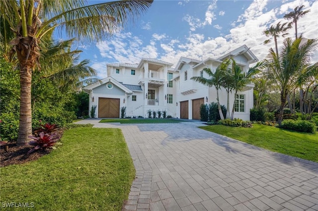 mediterranean / spanish-style house featuring a balcony, a front yard, and a garage